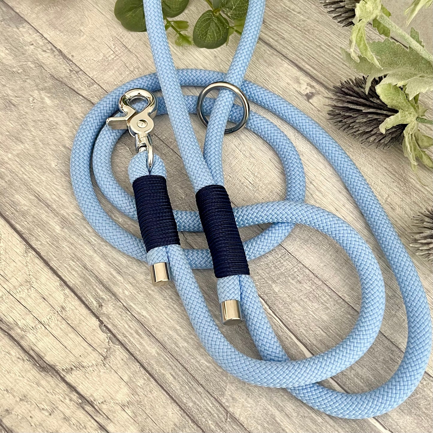 Polar Blue rope lead with Navy whipping securing a swivel clip at one end with whipping securing a handle at the other. The ends of the rope ends are finished with metal end caps. All hardware is in Silver
