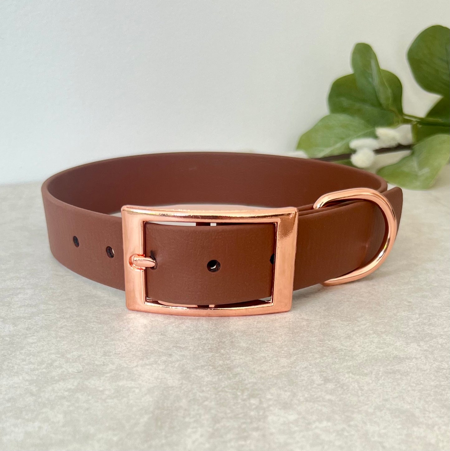 Biothane custom collar in Brown with Rose Gold buckle and a D-ring. The collar has 5 holes which are spaced 2cm apart. The collar is fastened on the first hole and has a soft leather appearance