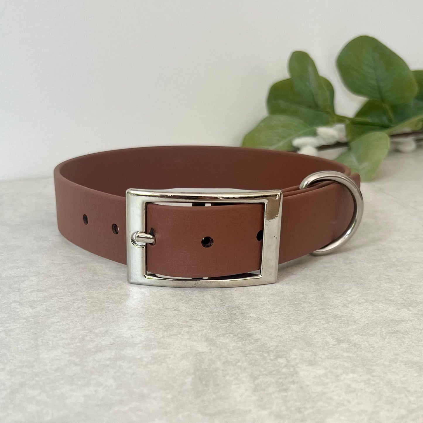Biothane custom collar in Brown with Silver buckle and a D-ring. The collar has 5 holes which are spaced 2cm apart. The collar is fastened on the first hole and has a soft leather appearance