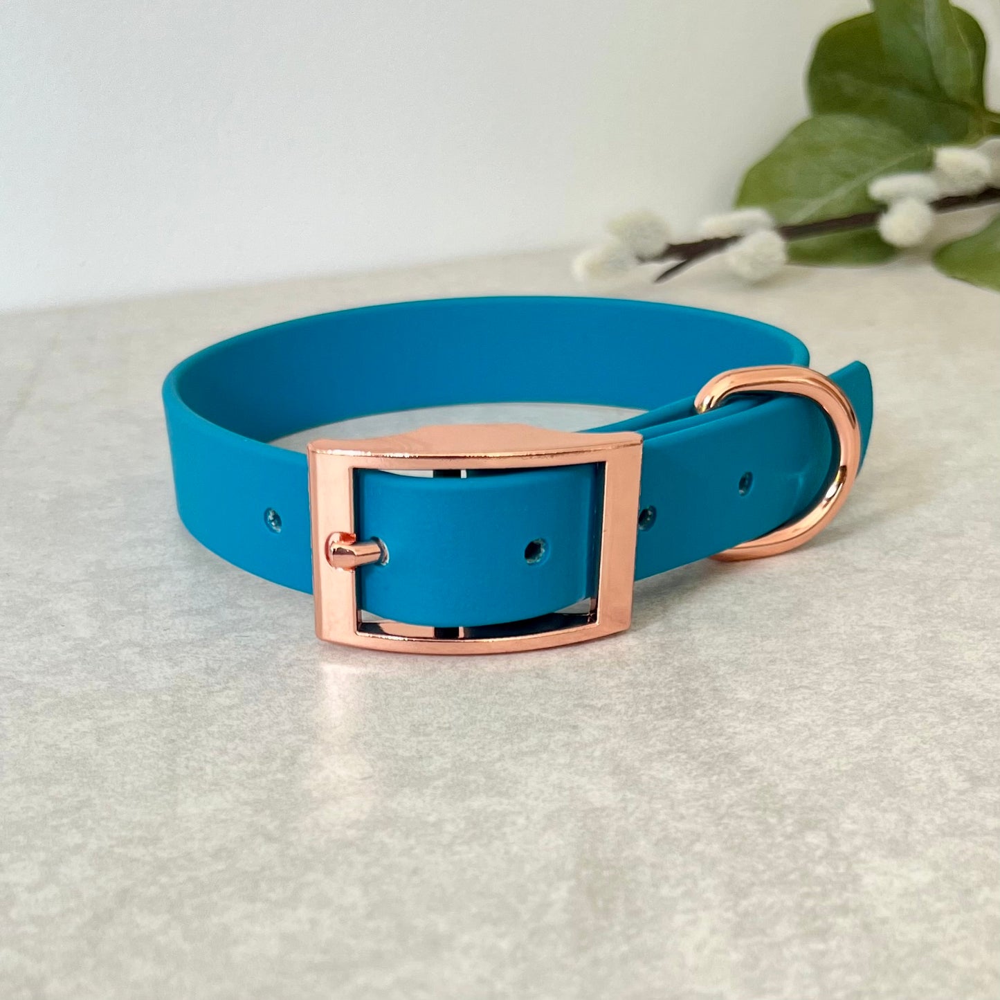 Biothane custom collar in Lagoon Blue with Rose Gold buckle and a D-ring. The collar has 5 holes which are spaced 2cm apart. Soft leather appearance