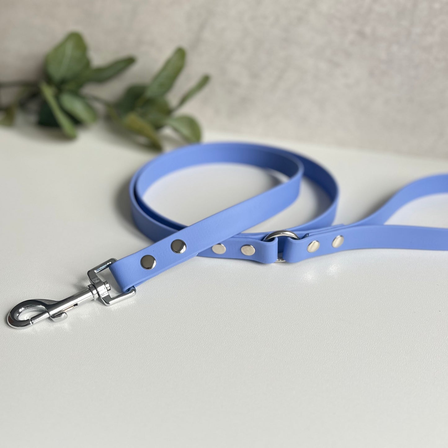 Periwinkle Biothane lead with Silver hardware. An O-ring connects the handle to the lead with double ended rivets fixing it together. A Snap Clip is fixed with double ended rivets. The lead has a soft leather appearance.