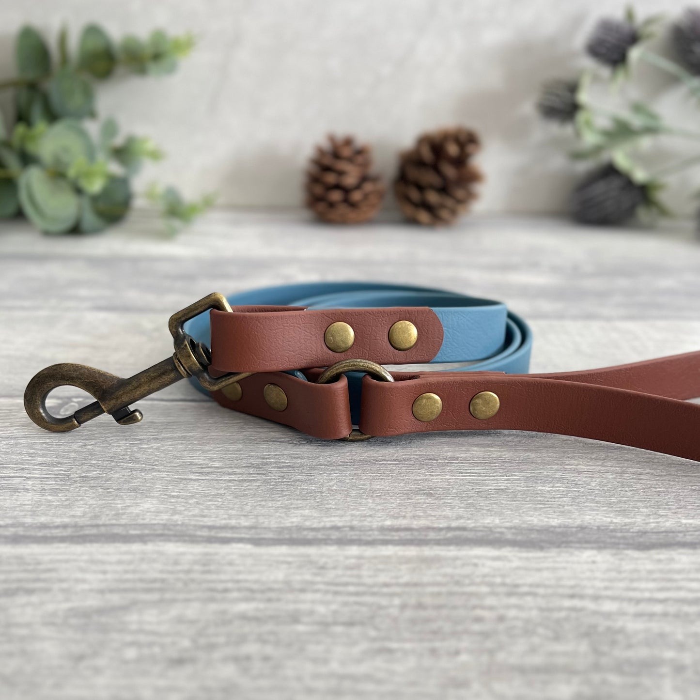 Two coloured Biothane dog lead. The handle and accent colour at the clip end of the lead is Brown, the mail lead colour is Petrol Blue giving the lead a two tone look. The hardware is Antique Brass