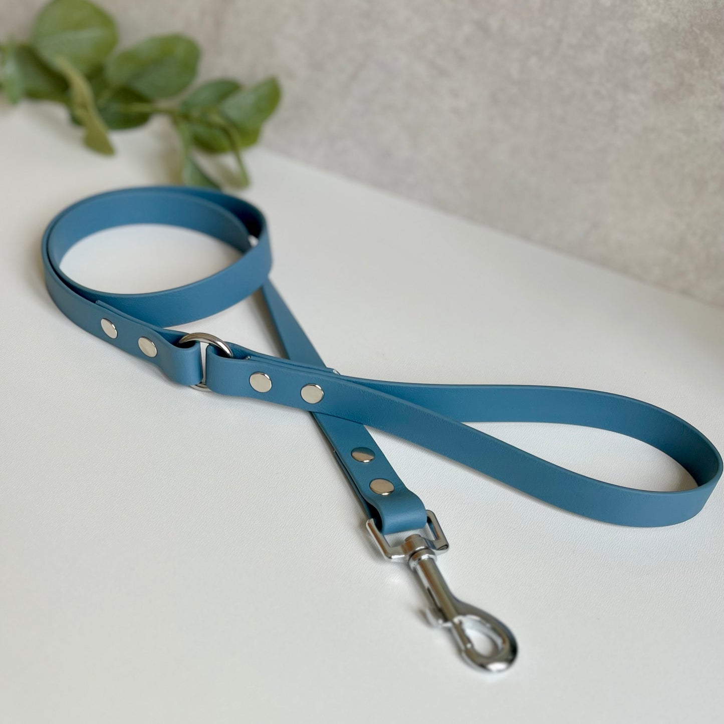 Petrol Blue Biothane lead with Silver Hardware. An O-ring connects the handle to the lead with double ended rivets fixing it together. A Snap Clip is fixed with double ended rivets. The lead has a soft leather appearance.