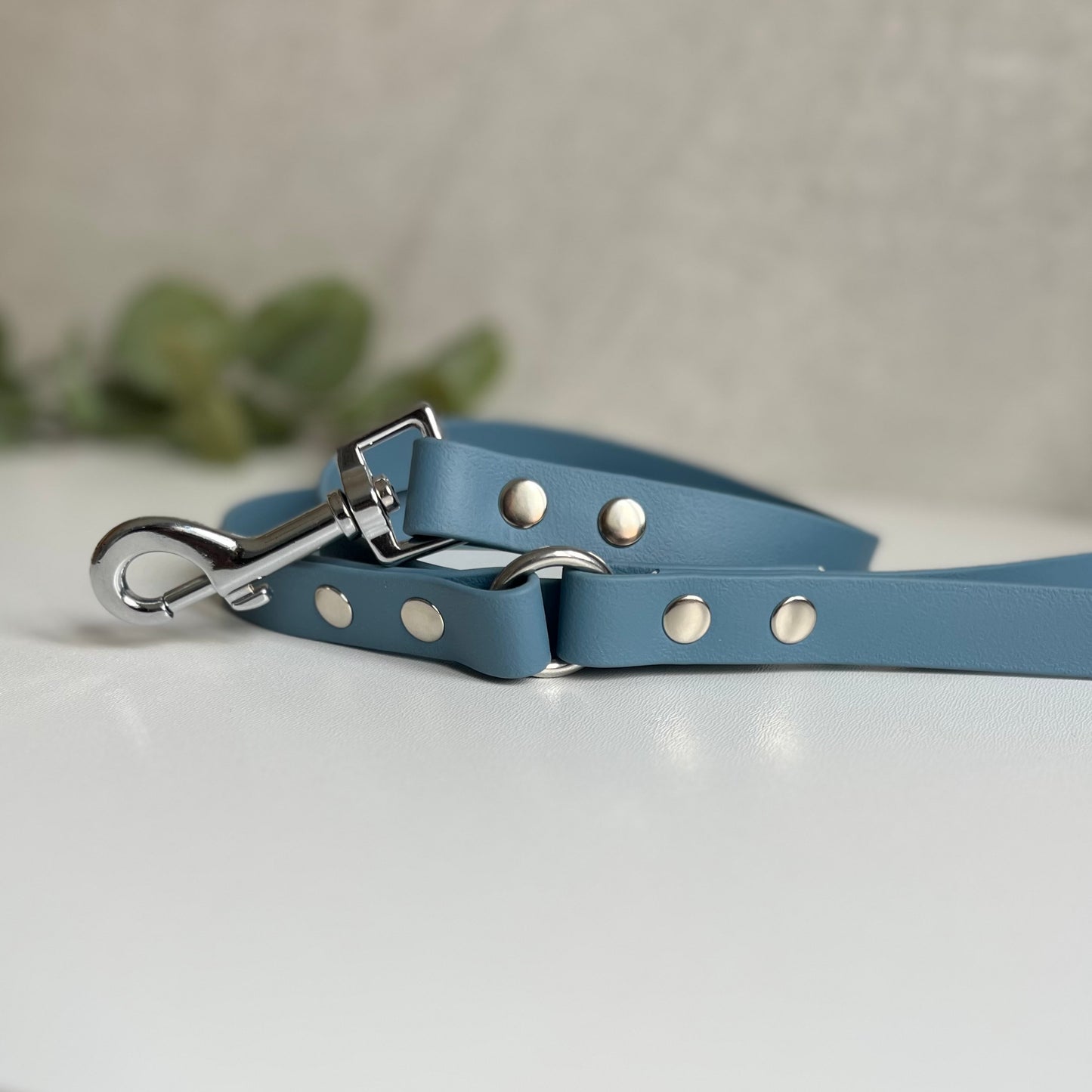 Petrol Blue Biothane lead with Silver Hardware. An O-ring connects the handle to the lead with double ended rivets fixing it together. A Snap Clip is fixed with double ended rivets. The lead has a soft leather appearance.