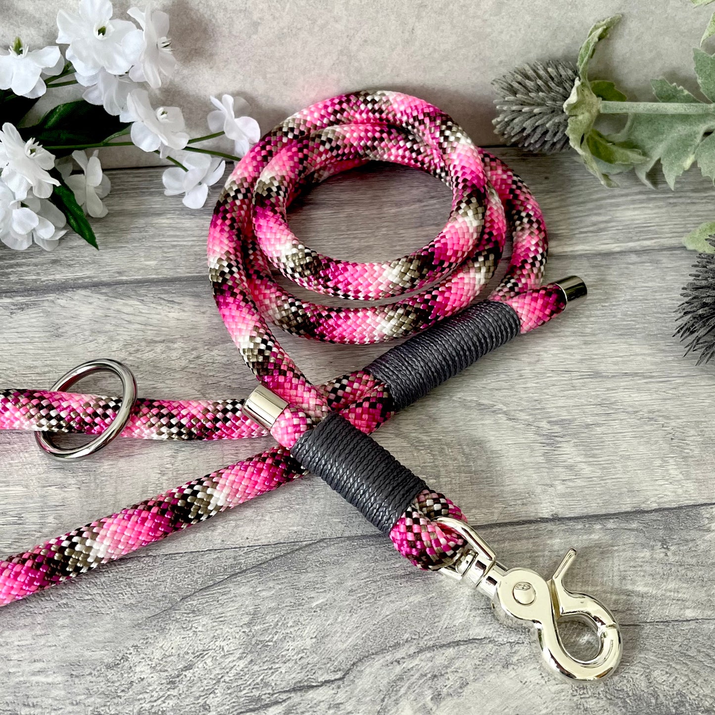 Cowgirl, pink rope lead with Charcoal whipping securing a swivel clip at one end and fastening a handle at the other. The handle has an O-ring attached. Each end of the rope is finished with a metal end cap. All hardware for this lead is in Silver