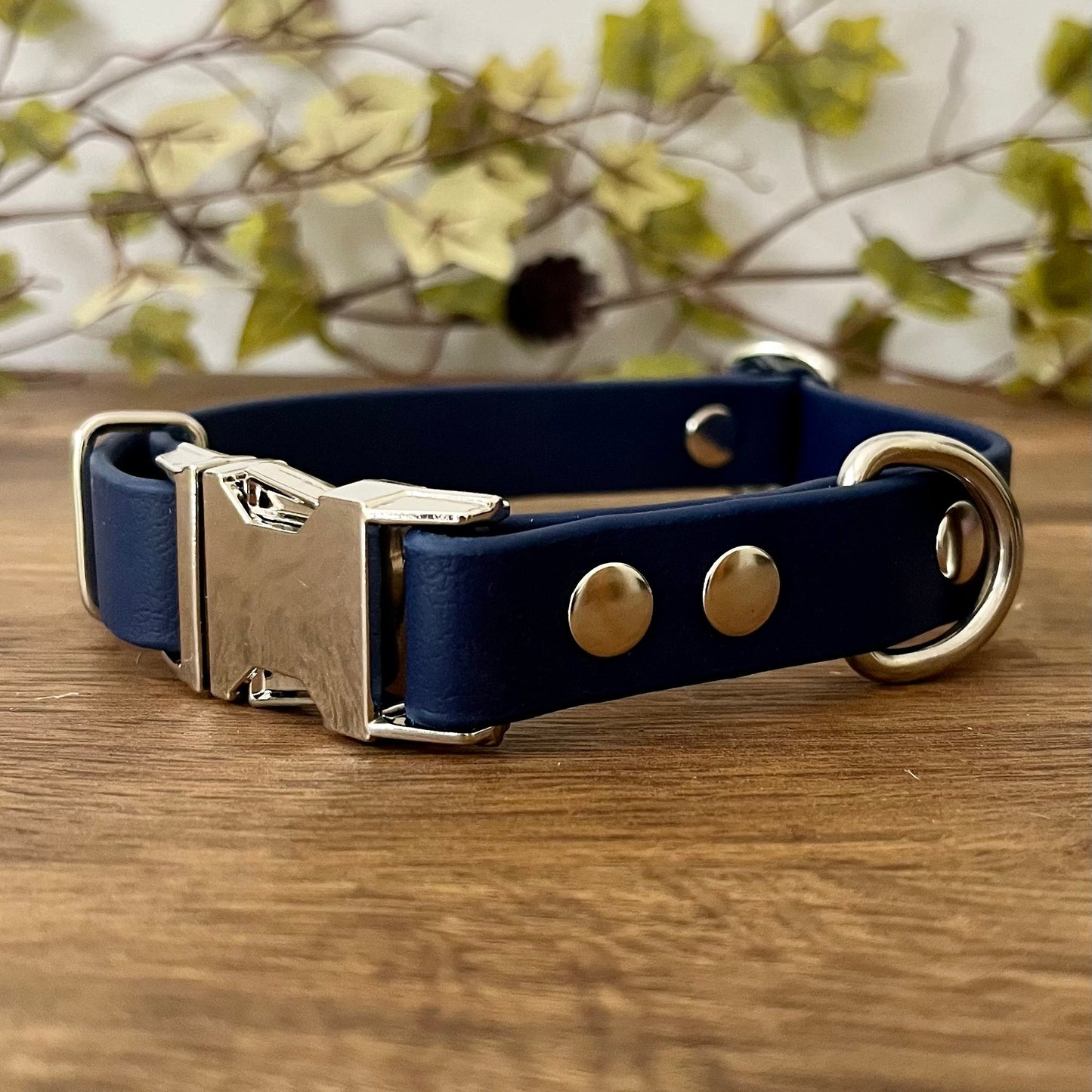 Made from Biothane in Navy Blue, the collar is fastened with a metal quick release buckle, metal rivets with a metal strap keeper on one side with a D-ring on the other. All hardware is in Silver