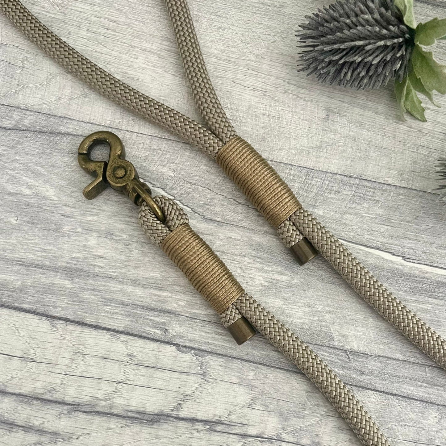 Tan rope dog lead with Gold Brown whipping securing a swivel clip at one end with whipping securing a handle at the other. The ends of the rope ends are finished with metal end caps. All hardware is in Antique Brass