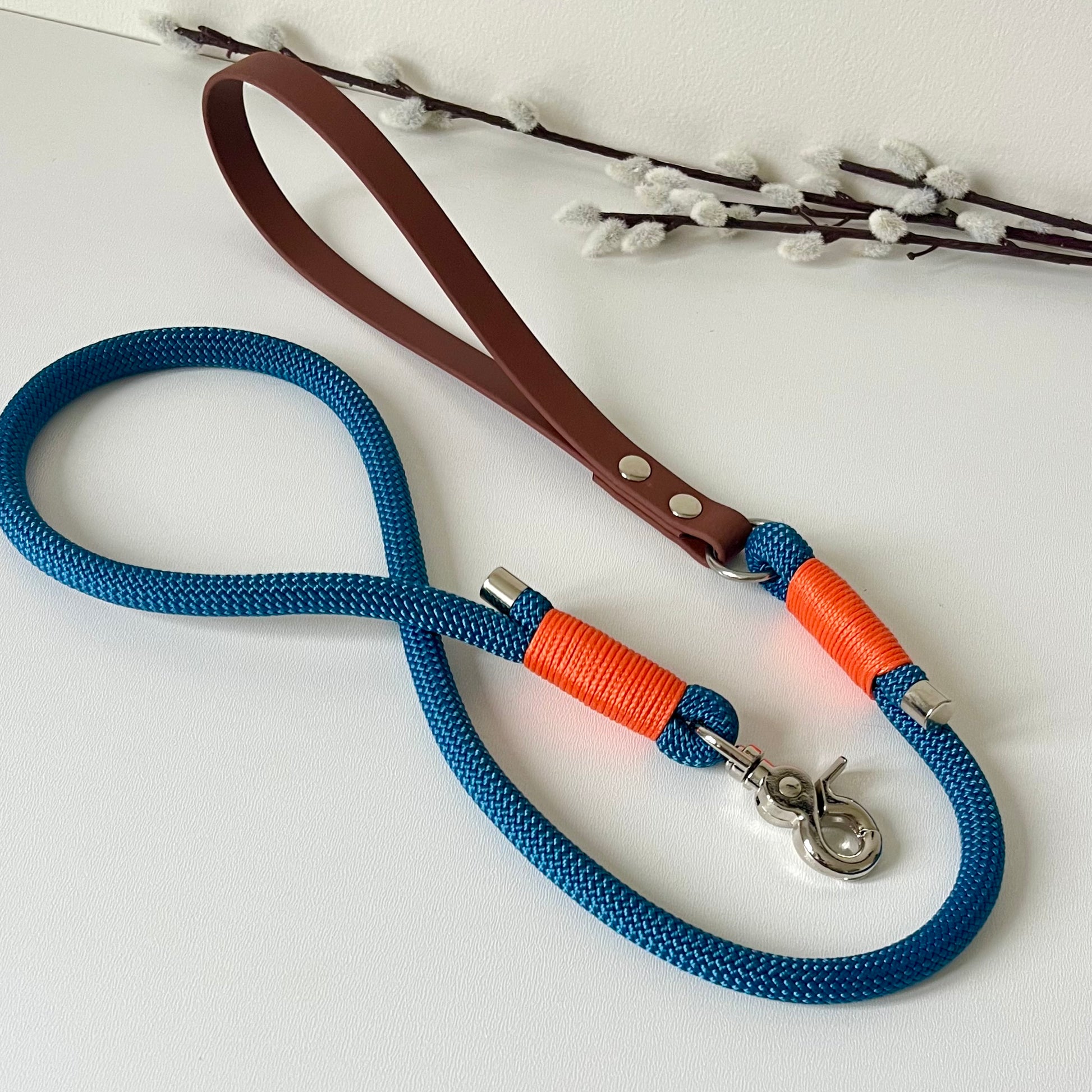 Blue rope dog lead with a brown BioThane handle, orange binding and silver hardware