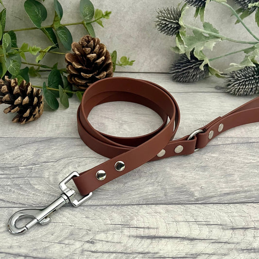 Brown Biothane lead with Silver Hardware. An O-ring connects the handle to the lead with double ended rivets fixing it together. A Snap Clip is fixed with double ended rivets. The lead has a soft leather appearance.