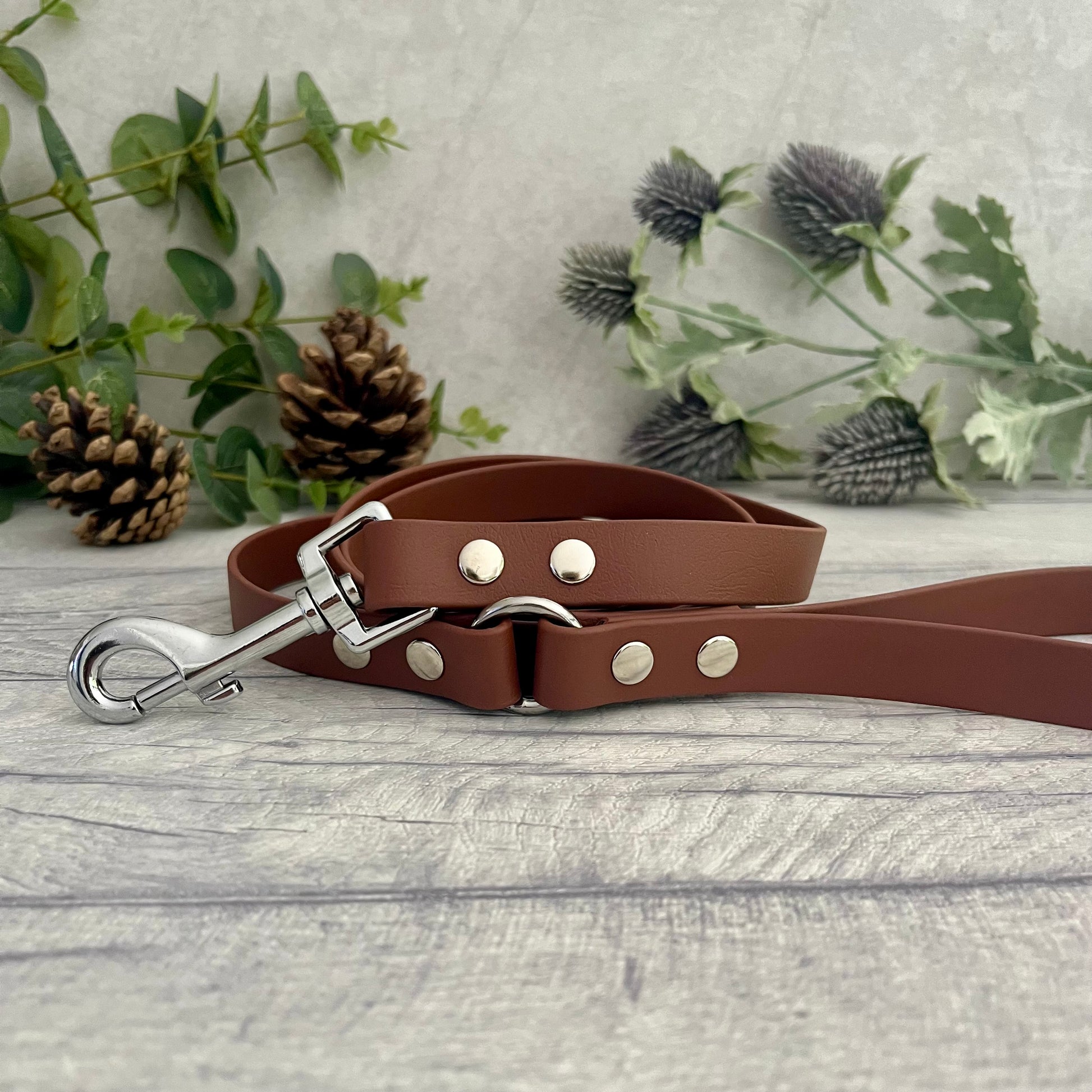 Brown Biothane lead with Silver Hardware. An O-ring connects the handle to the lead with double ended rivets fixing it together. A Snap Clip is fixed with double ended rivets. The lead has a soft leather appearance.