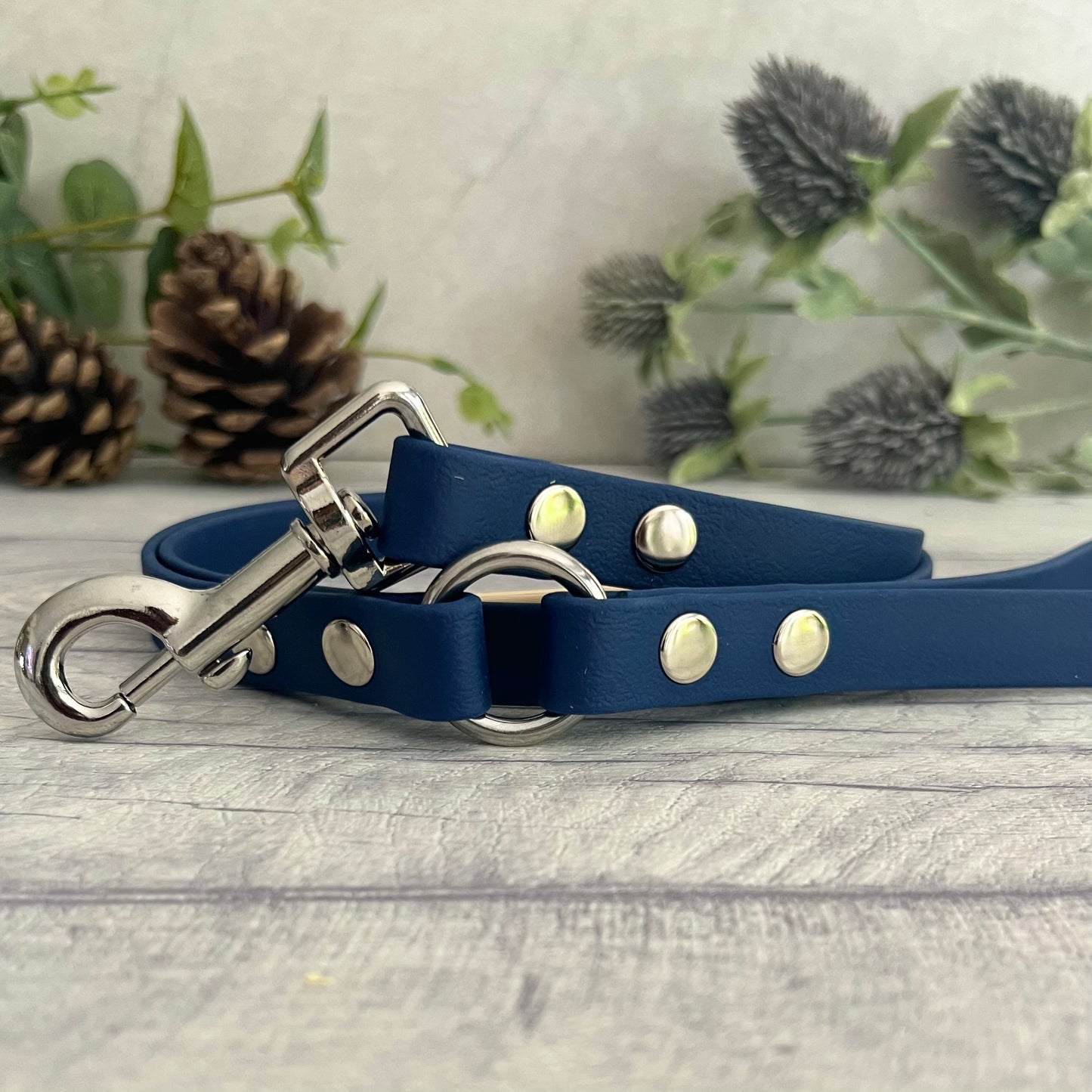 Navy Blue Biothane lead with Silver Hardware. An O-ring connects the handle to the lead with double ended rivets fixing it together. A Snap Clip is fixed with double ended rivets. The lead has a soft leather appearance.