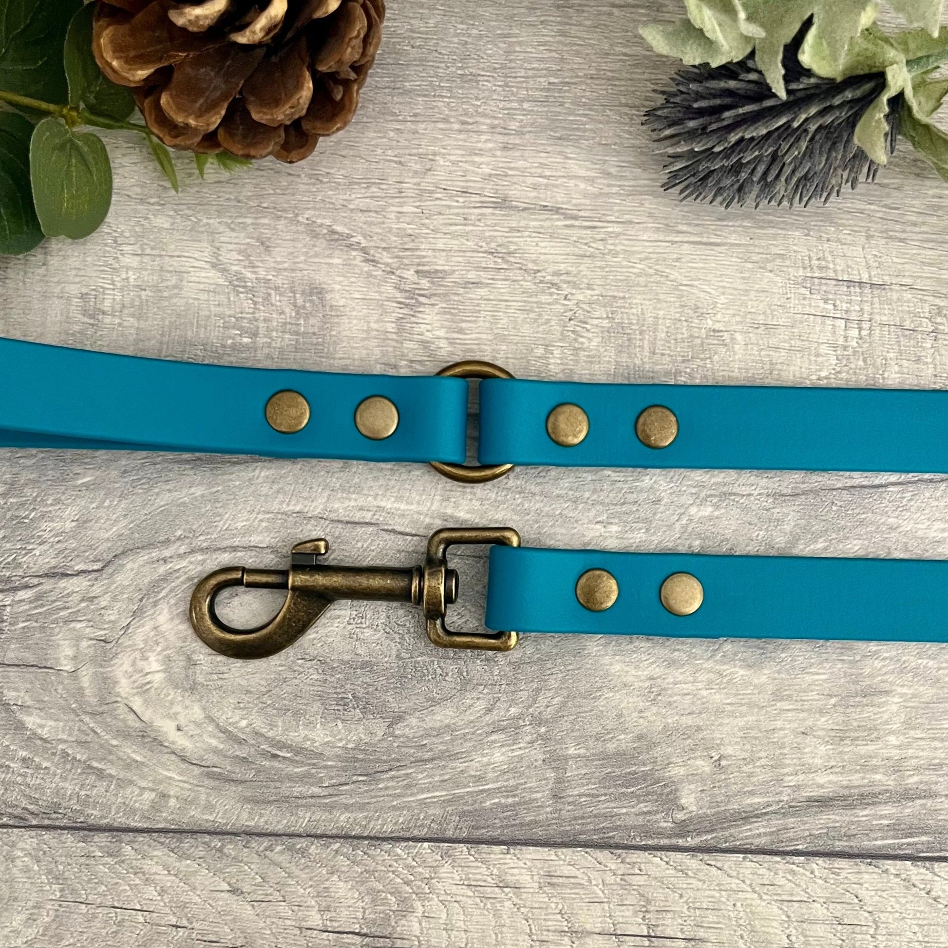 Biothane lead in Lagoon with Antique Brass hardware. An O-ring connects the handle to the lead with double ended rivets fixing it together. A Snap Clip is fixed with double ended rivets. The lead has a soft leather appearance.