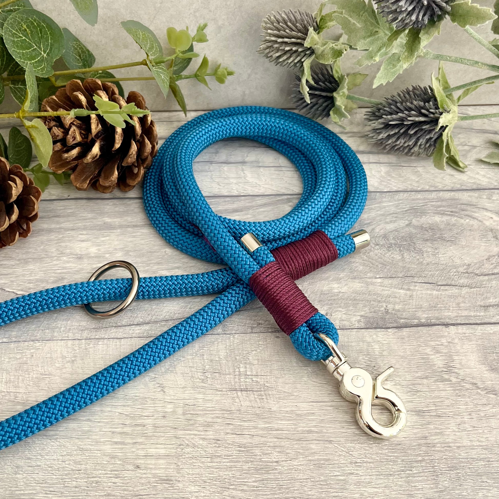 Lapis Blue rope lead with Aubergine whipping securing a swivel clip at one end with whipping securing a handle at the other. The ends of the rope ends are finished with metal end caps. All hardware is in Silver