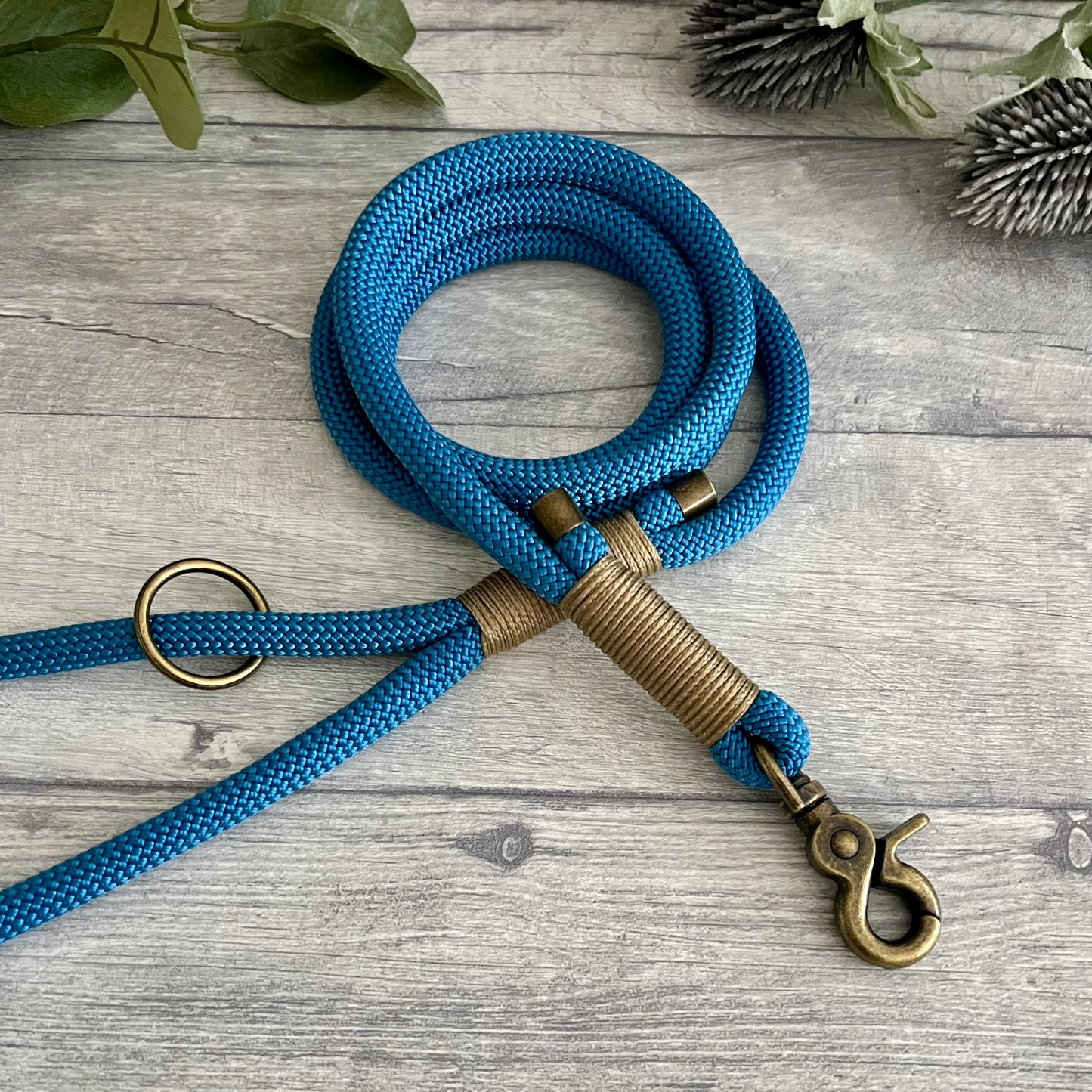 Lapis Blue rope lead with Gold Brown whipping securing a swivel clip at one end with whipping securing a handle at the other. The ends of the rope ends are finished with metal end caps. All hardware is in Antique Brass