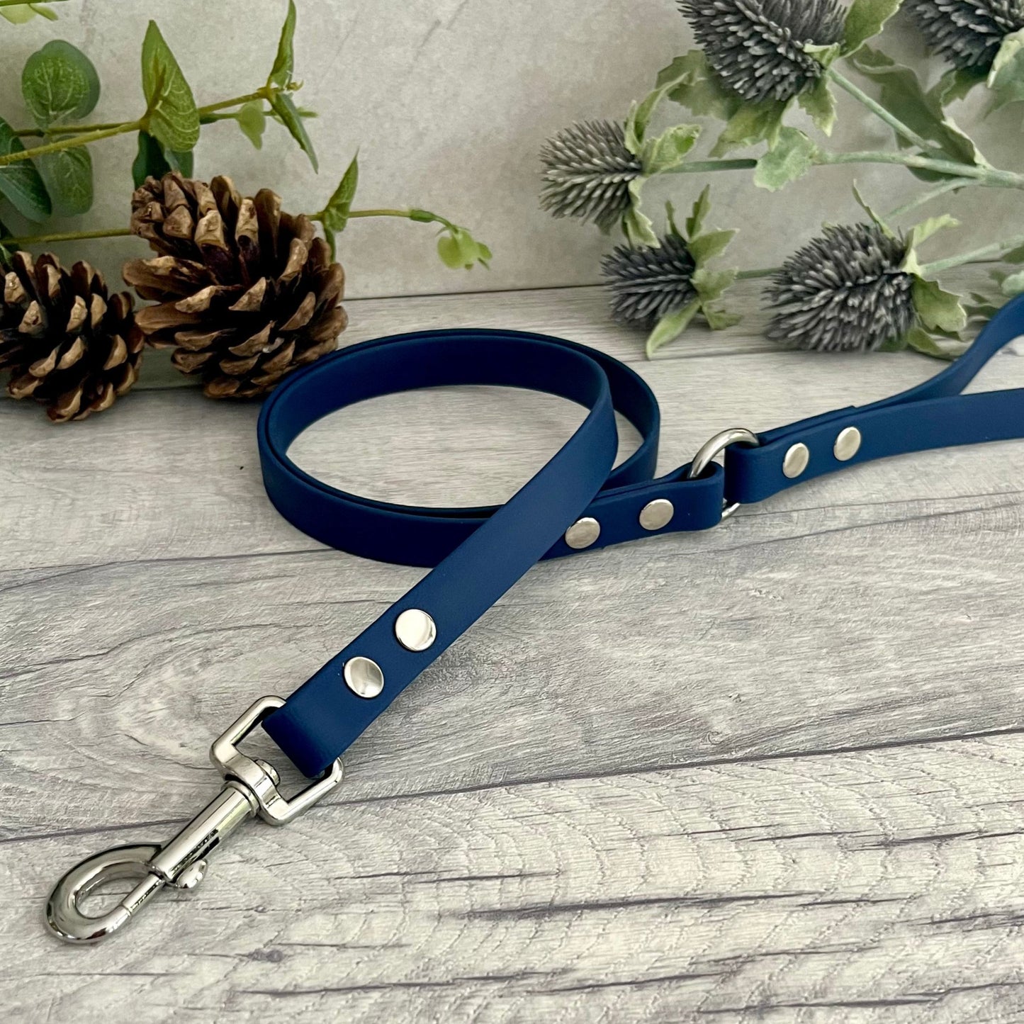 Navy Blue Biothane lead with Silver Hardware. An O-ring connects the handle to the lead with double ended rivets fixing it together. A Snap Clip is fixed with double ended rivets. The lead has a soft leather appearance.