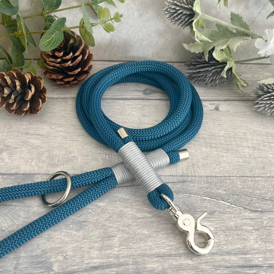 Petrol Blue rope lead with Silver Grey whipping securing a swivel clip at one end and fastening a handle at the other. The handle has an O-ring attached. Each end of the rope is finished with a metal end cap. All hardware for this lead is in Sliver