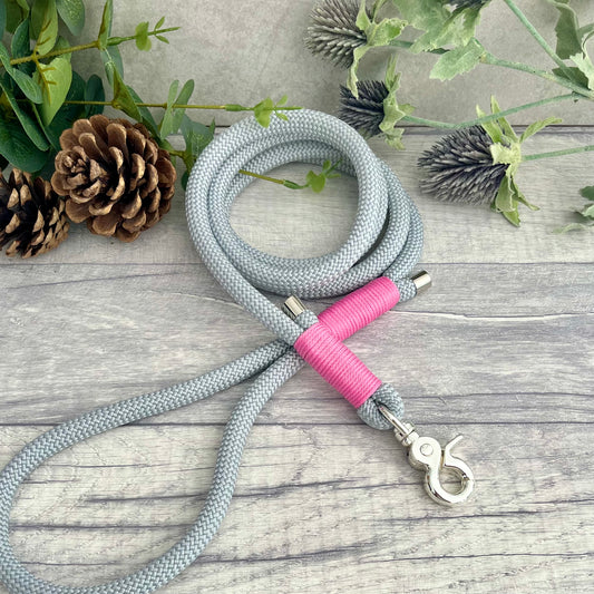 Silver Grey rope lead with Rose Pink whipping securing a swivel clip at one end and fastening a handle at the other. The handle has an O-ring attached. Each end of the rope is finished with a metal end cap. All hardware for this lead is in Silver
