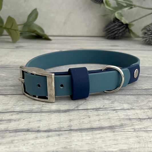 Two tone dog collar in Petrol Blue & Navy. The collar strap is two colours fixed together with a rivet. The collar has a Biothane strap keeper and a metal D-ring with 5 x punched holes. All hardware is Silver