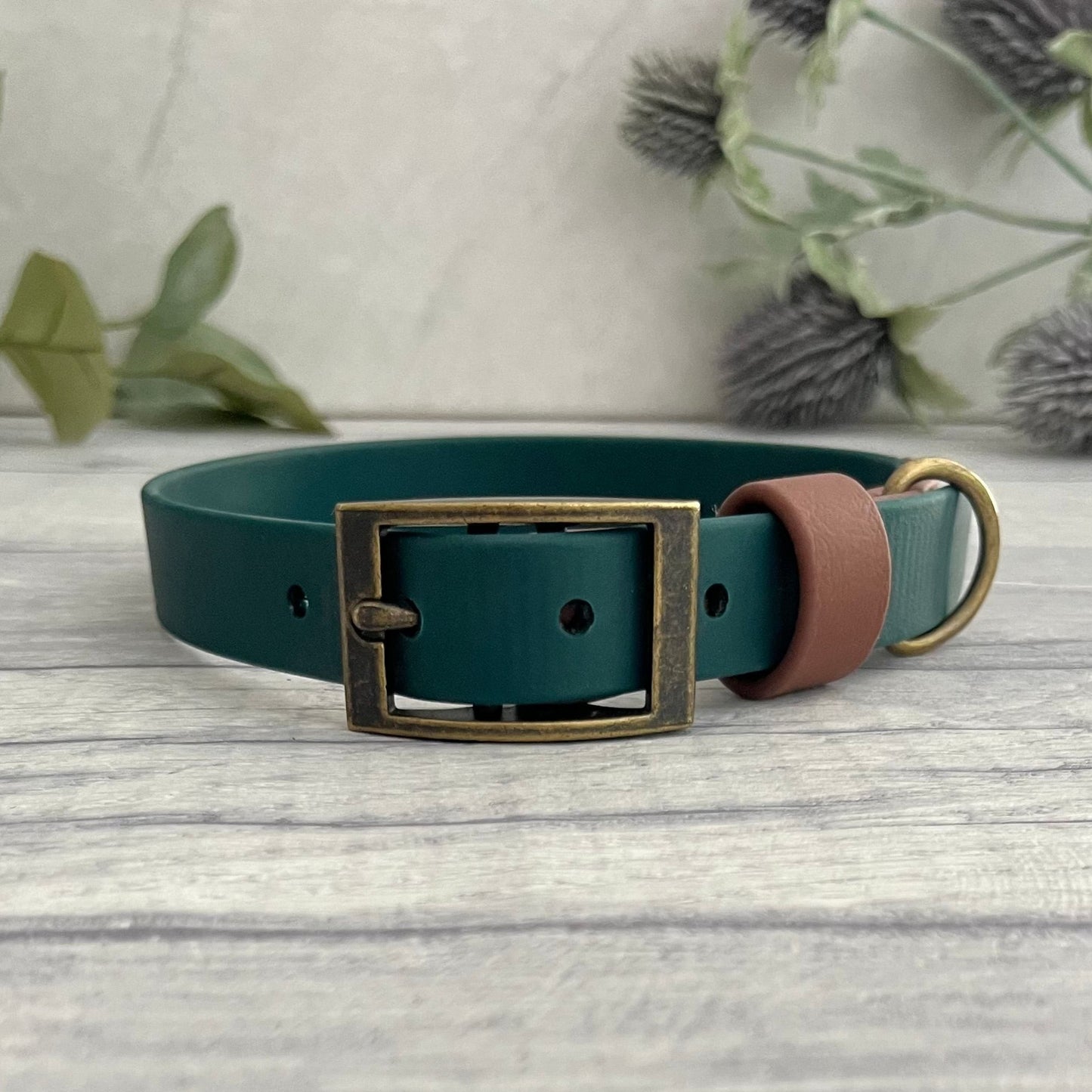 Two tone dog collar in Dark green & Brown. The collar strap is two colous fixed together with a rivet. The collar has a Biothane strap keeper and a metal D-ring with 5 x punched holes. All hardware is Antique Brass