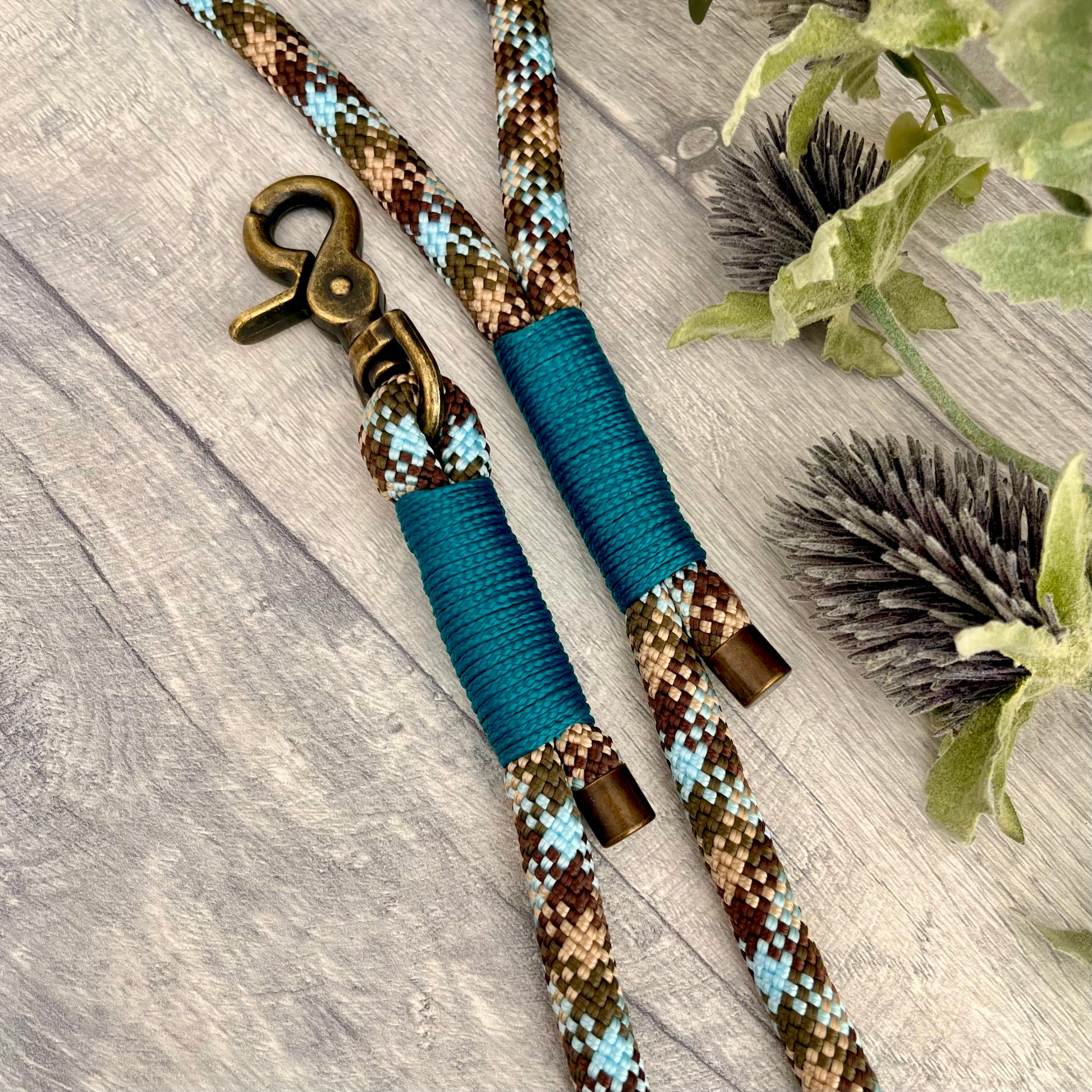 Tundra, Brown & Blue rope dog lead with Aqua whipping securing a swivel clip at one end and fastening a handle at the other. The handle has an O-ring attached. Each end of the rope is finished with a metal end cap. All hardware for this lead is in Antique Brass