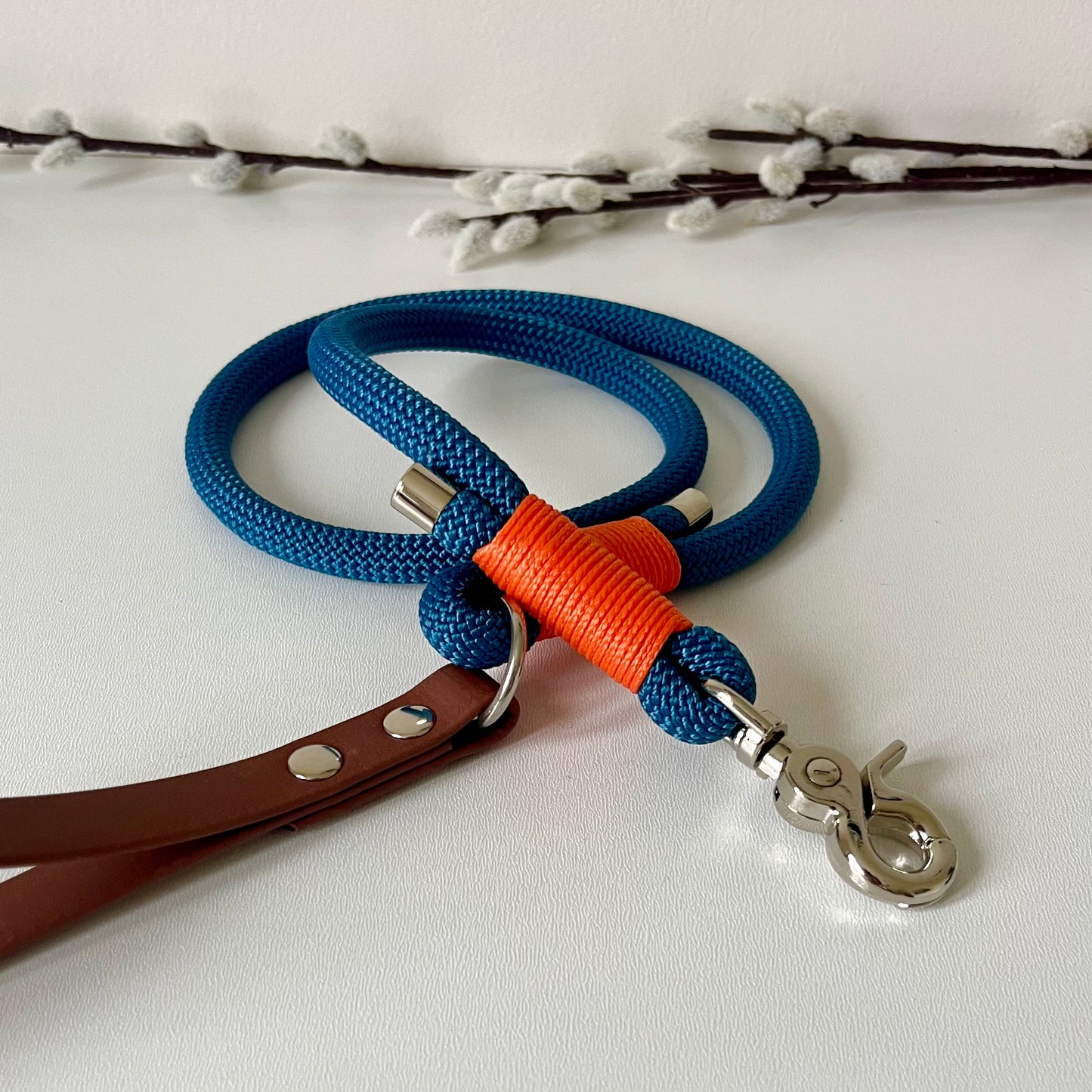 Blue rope dog lead with a brown BioThane handle, orange binding and silver hardware