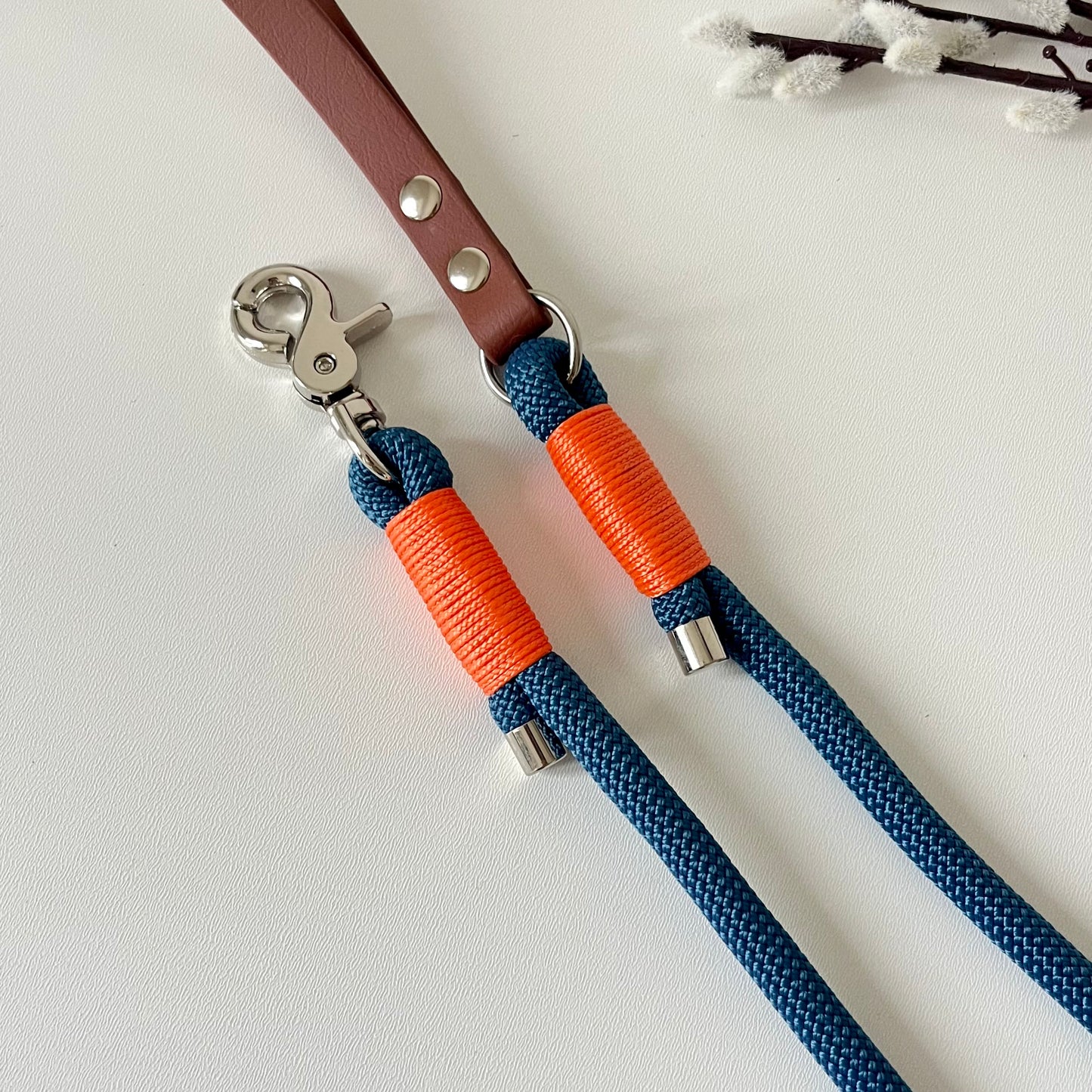 Blue rope dog lead with a brown BioThane handle, orange binding and silver hardware