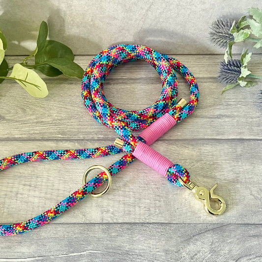 Confetti multi coloured rope lead with Rose Pink whipping securing a swivel clip at one end and fastening a handle at the other. The handle has an O-ring attached. Each end of the rope is finished with a metal end cap. All hardware for this lead is in Gold
