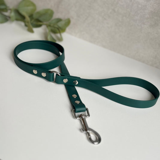 Dark Green Biothane lead with Silver Hardware. An O-ring connects the handle to the lead with double ended rivets fixing it together. A Snap Clip is fixed with double ended rivets. The lead has a soft leather appearance.