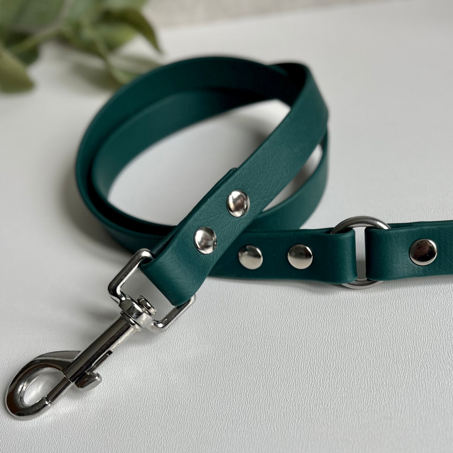 Dark Green Biothane lead with Silver Hardware. An O-ring connects the handle to the lead with double ended rivets fixing it together. A Snap Clip is fixed with double ended rivets. The lead has a soft leather appearance.