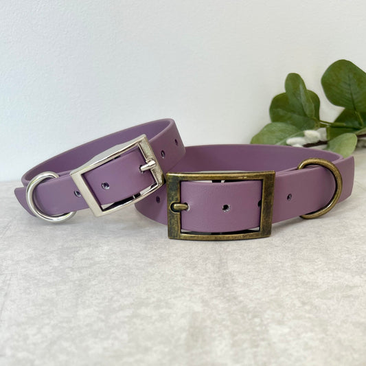 Two Mauve Biothane dog collars with Silver & Antique Brass hardware. The collars are fastened with a buckle and have a d-ring. There are 5 punched holes spaced 2cm apart.