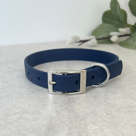 Navy Biothane dog collar with Silver hardware. The collar is fastened with a buckle and has a d-ring. There are 5 punched holes spaced 2cm apart.