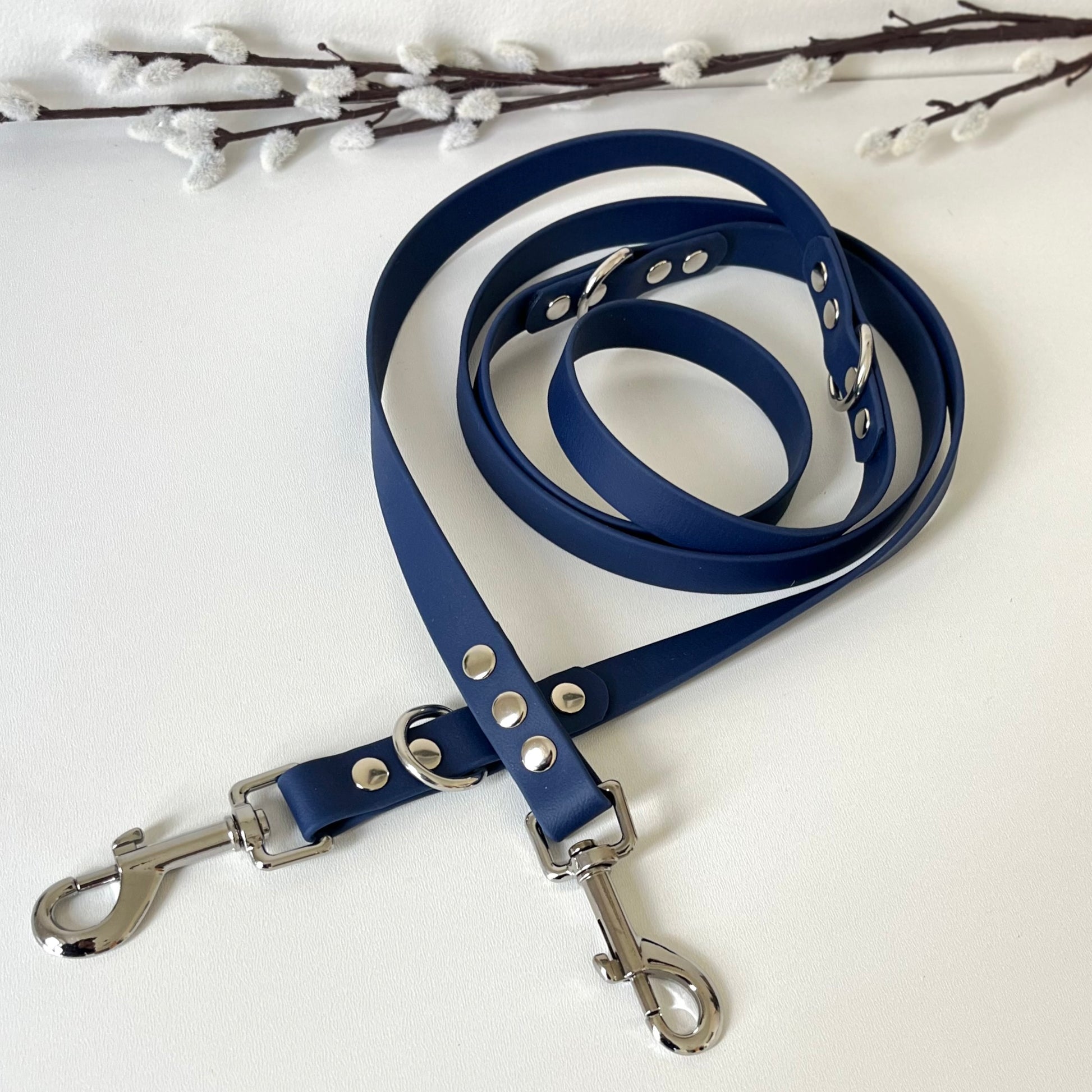 Blue biothane dog lead with silver hardware on a white background