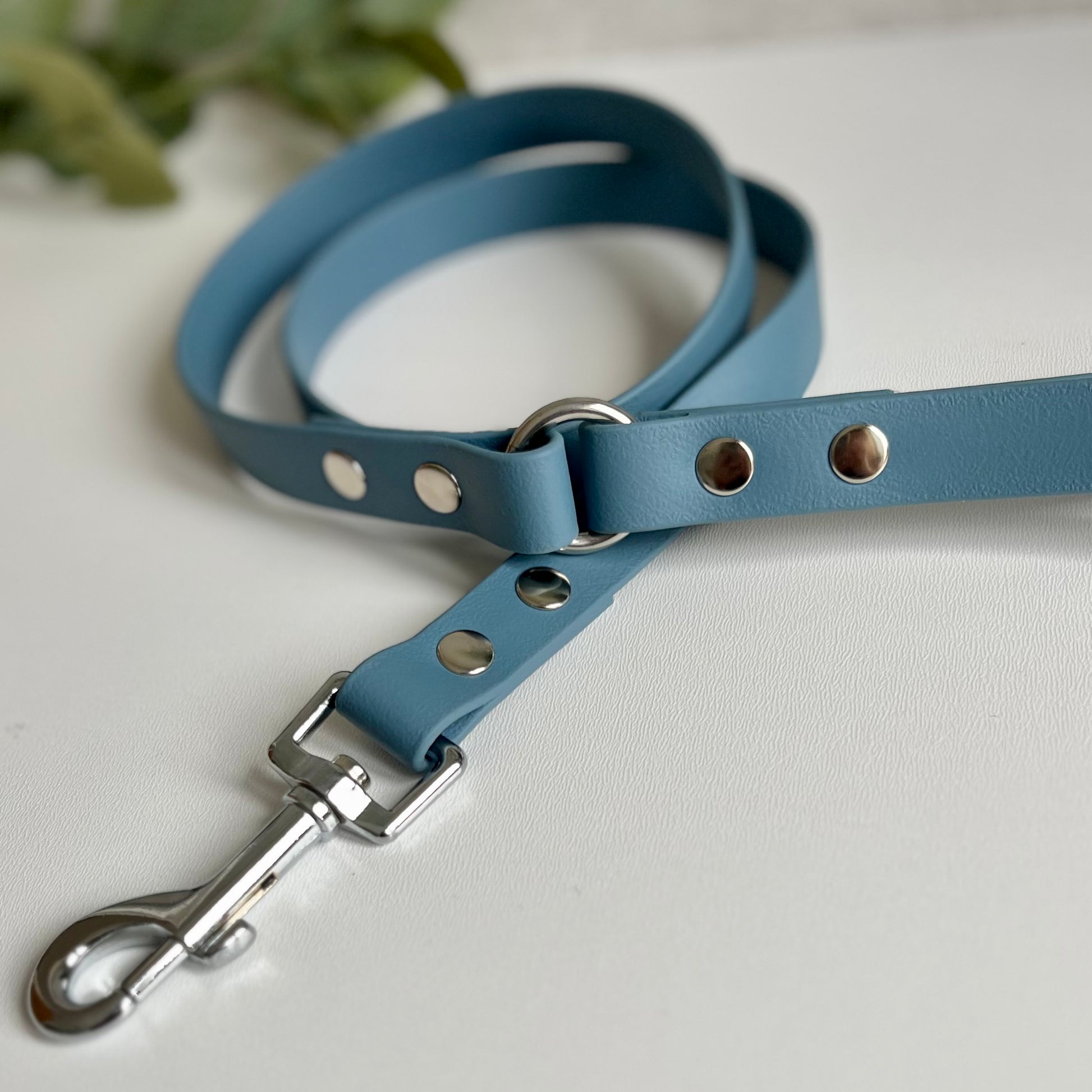 Petrol Blue Biothane lead with Silver Hardware. An O-ring connects the handle to the lead with double ended rivets fixing it together. A Snap Clip is fixed with double ended rivets. The lead has a soft leather appearance.