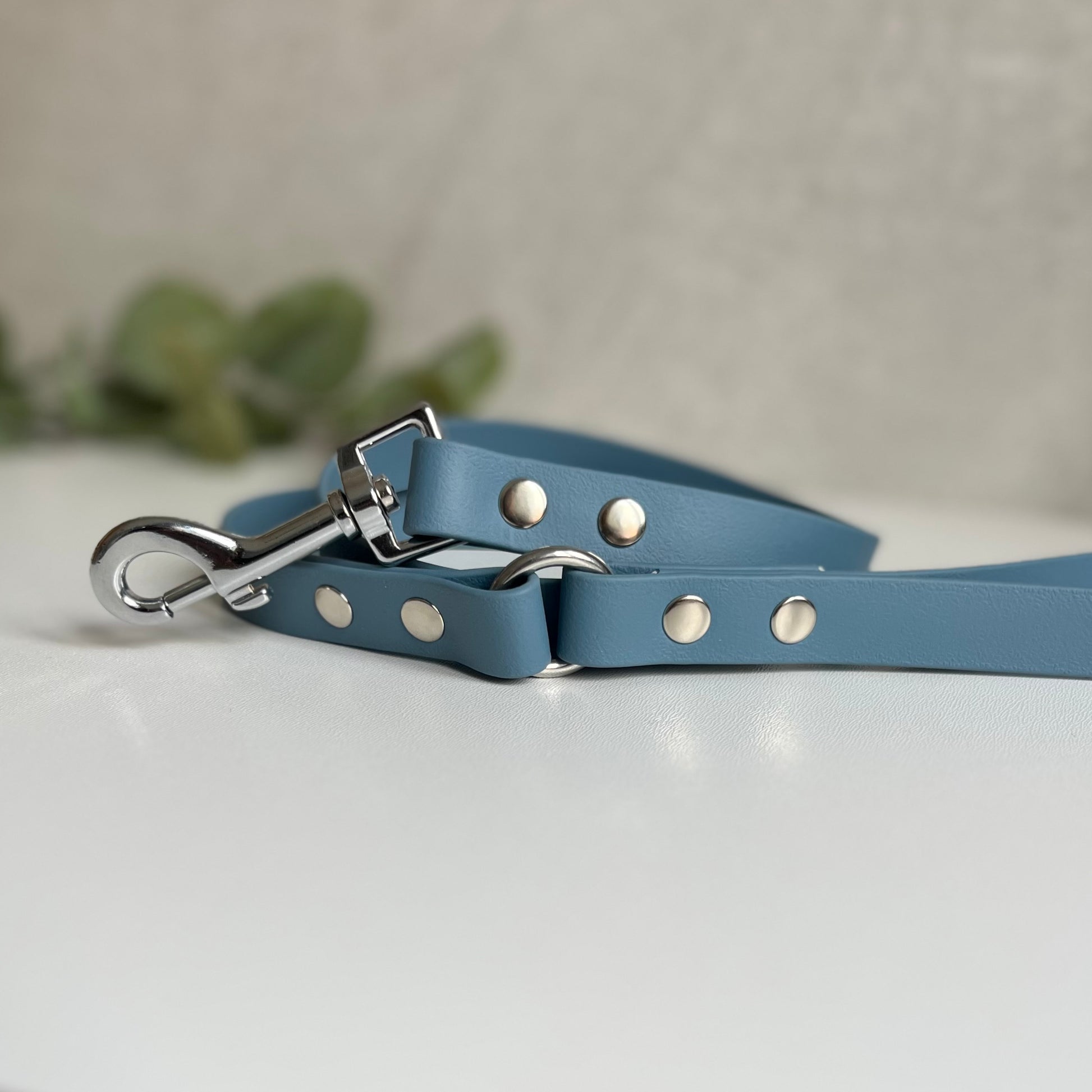 Petrol Blue Biothane lead with Silver Hardware. An O-ring connects the handle to the lead with double ended rivets fixing it together. A Snap Clip is fixed with double ended rivets. The lead has a soft leather appearance.