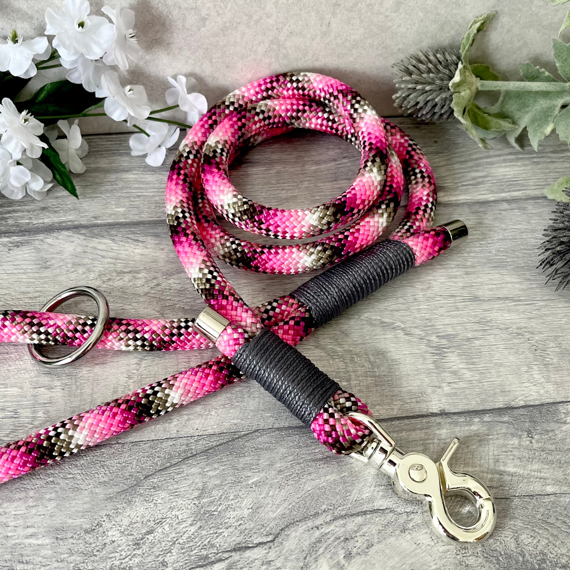 Cowgirl, pink rope lead with Charcoal whipping securing a swivel clip at one end and fastening a handle at the other. The handle has an O-ring attached. Each end of the rope is finished with a metal end cap. All hardware for this lead is in Silver