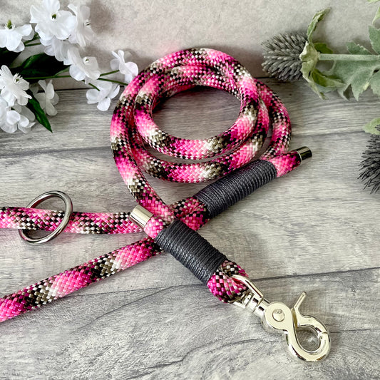 Cowgirl, pink rope lead with Charcoal whipping securing a swivel clip at one end and fastening a handle at the other. The handle has an O-ring attached. Each end of the rope is finished with a metal end cap. All hardware for this lead is in Silver