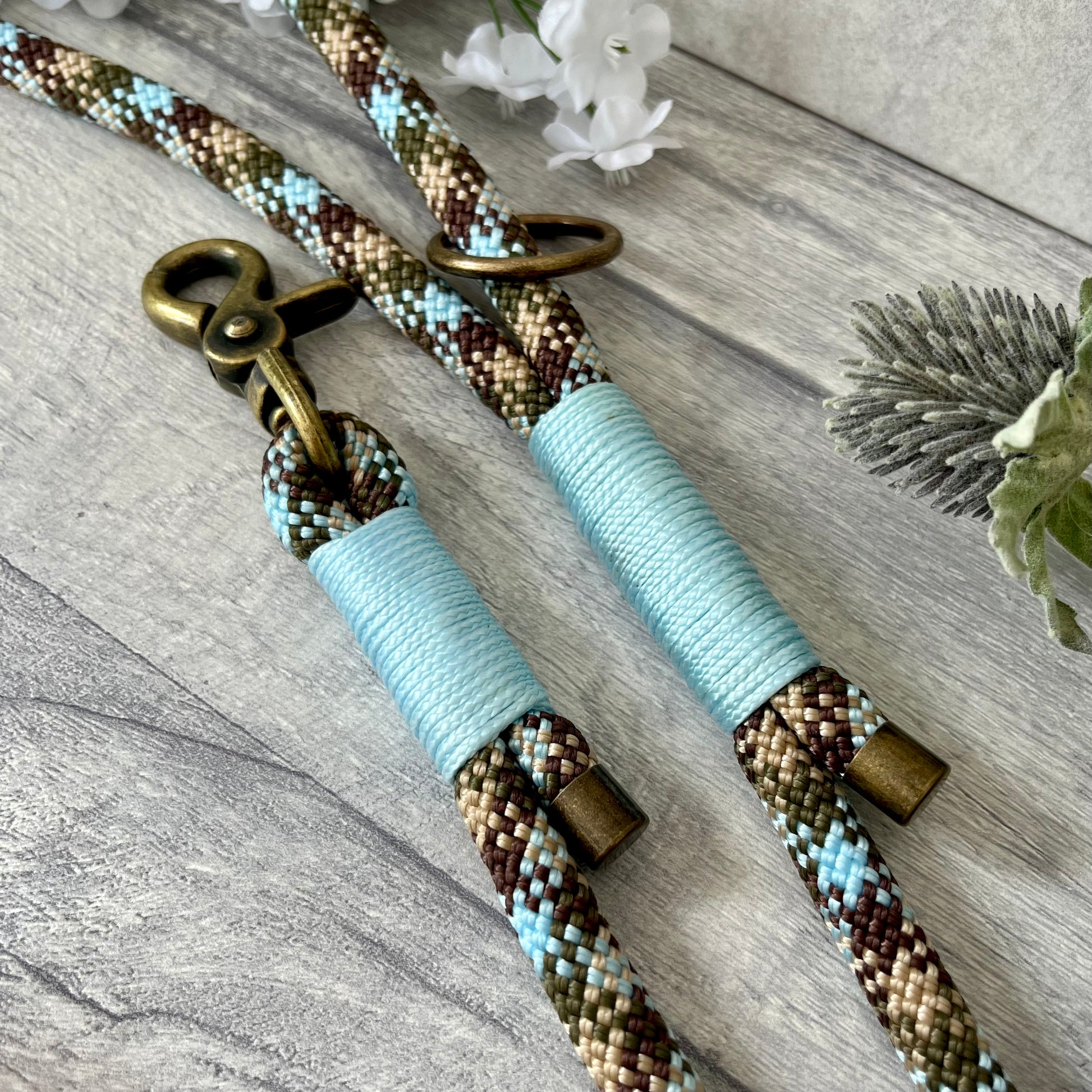 Tundra, Brown & Blue rope dog lead with Baby Blue whipping securing a swivel clip at one end and fastening a handle at the other. The handle has an O-ring attached. Each end of the rope is finished with a metal end cap. All hardware for this lead is in Antique Brass